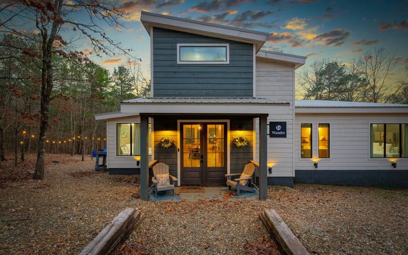 Rowdy Creek exterior at dusk with string lights and Adirondack chairs.